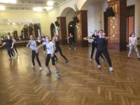 grupa ćwiczących w sali balowej